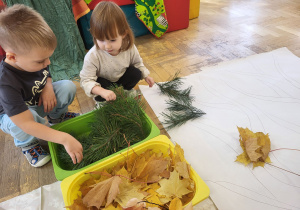 Dzieci układają obrazki z naturalnych materiałów