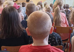 dzieci siedzą i oglądają teatrzyk