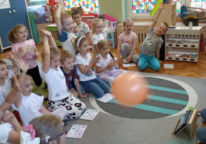 dzieci siedzą na dywanie