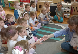 dzieci siedzą na dywanie