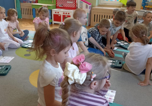 dzieci siedzą na dywanie