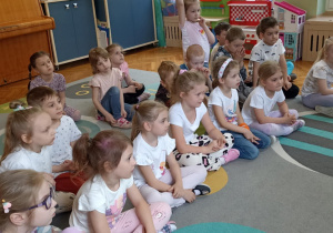dzieci siedzą na dywanie
