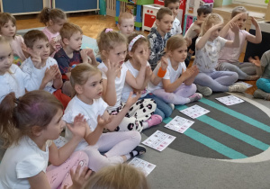 dzieci siedzą na dywanie