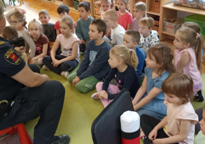 dzieci siedzą na dywanie