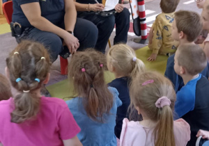dzieci siedzą na dywanie
