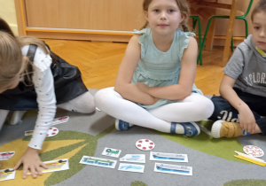 dzieci siedzą na dywanie i liczą