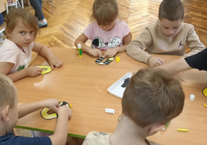 dzieci kolorują literę o i doklejają elementy