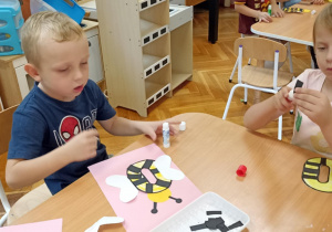 dzieci kolorują literę o i doklejają elementy
