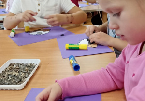 dzieci wyklejają jeża pestkami słonecznnika