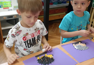 dzieci wyklejają jeża pestkami słonecznnika