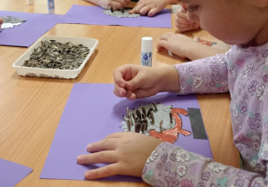 dzieci wyklejają jeża pestkami słonecznnika