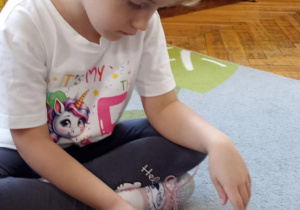 dzieci układają puzzle na dywanie