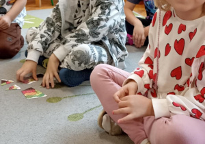 dzieci układają puzzle na dywanie