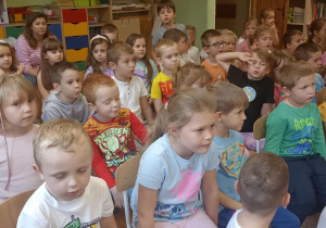 dzieci siedzą na krzesełkach