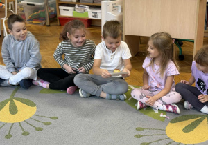 dzieci przekazują sobie jabłko na talerzyku