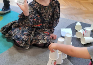 Dzieci układają jesienną wieżę z kubków wg wzoru