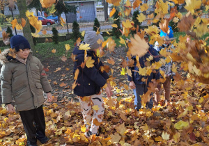 dzieci rzucają liśćmi
