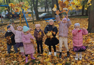 dzieci rzucają liśćmi