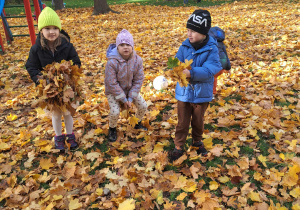 dzieci rzucają liśćmi
