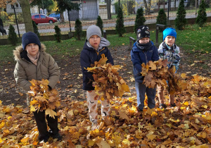 dzieci rzucają liśćmi