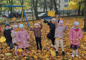 dzieci rzucają liśćmi