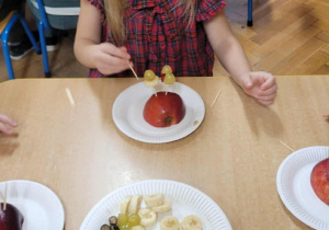 Dzieci wykonują jeżyki z owoców