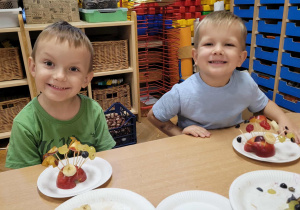 Dzieci wykonują jeżyki z owoców