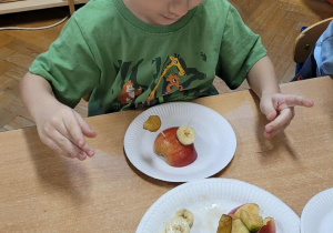 Dzieci wykonują jeżyki z owoców