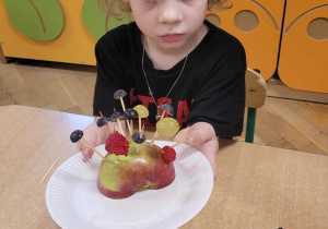 Dzieci wykonują jeżyki z owoców