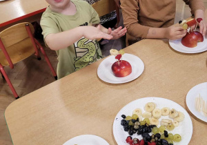 Dzieci wykonują jeżyki z owoców