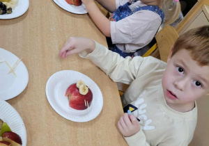Dzieci wykonują jeżyki z owoców