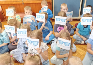 dzieci siedzą z flagami