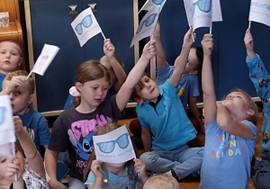 dzieci siedzą z flagami