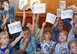 dzieci siedzą z flagami