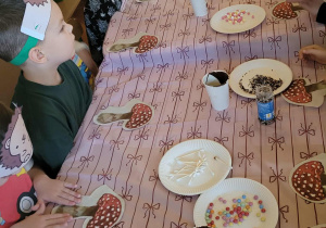 Dzieci wykonują jeże z ciasteczek