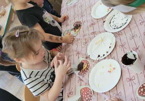 Dzieci wykonują jeże z ciasteczek