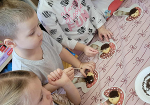 Dzieci wykonują jeże z ciasteczek