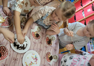 Dzieci wykonują jeże z ciasteczek