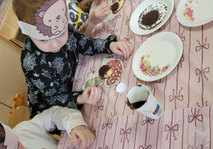 Dzieci wykonują jeże z ciasteczek