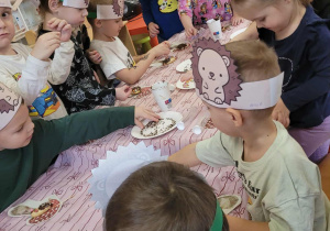Dzieci wykonują jeże z ciasteczek
