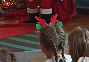 Mikołaj siedzi przy choince