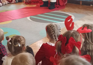 Mikołaj siedzi przy choince