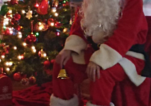 Mikołaj siedzi przy choince