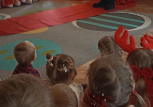 Mikołaj stoi przy choince