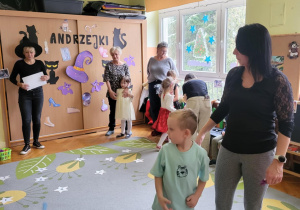 dzieci z rodzicami stoją na dywanie