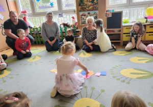 dzieci i rodzice siedzą na dywanie