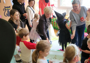 dzieci i rodzice siedzą na dywanie