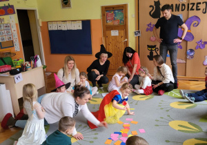 dzieci i rodzice siedzą na dywanie