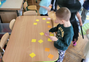 chłopiec sięga karteczkę