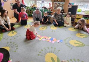 dzieci i rodzice siedzą na dywanie